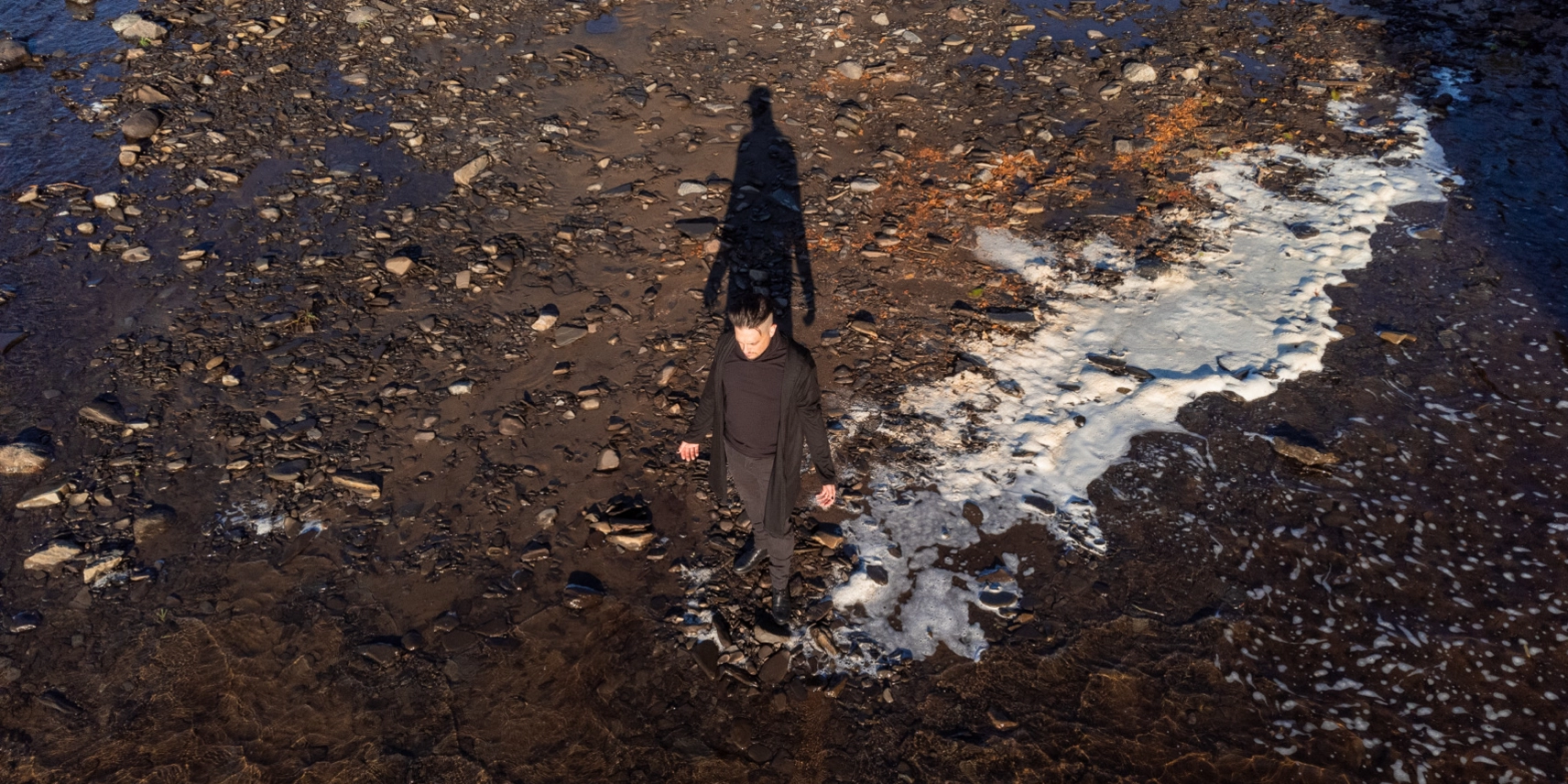 Drone photo of David at the edge of a river